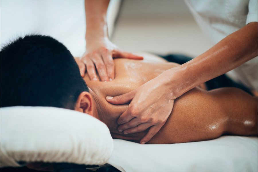 Social Distancing with Massage Therapy. Picture of man with dark hair getting a massage